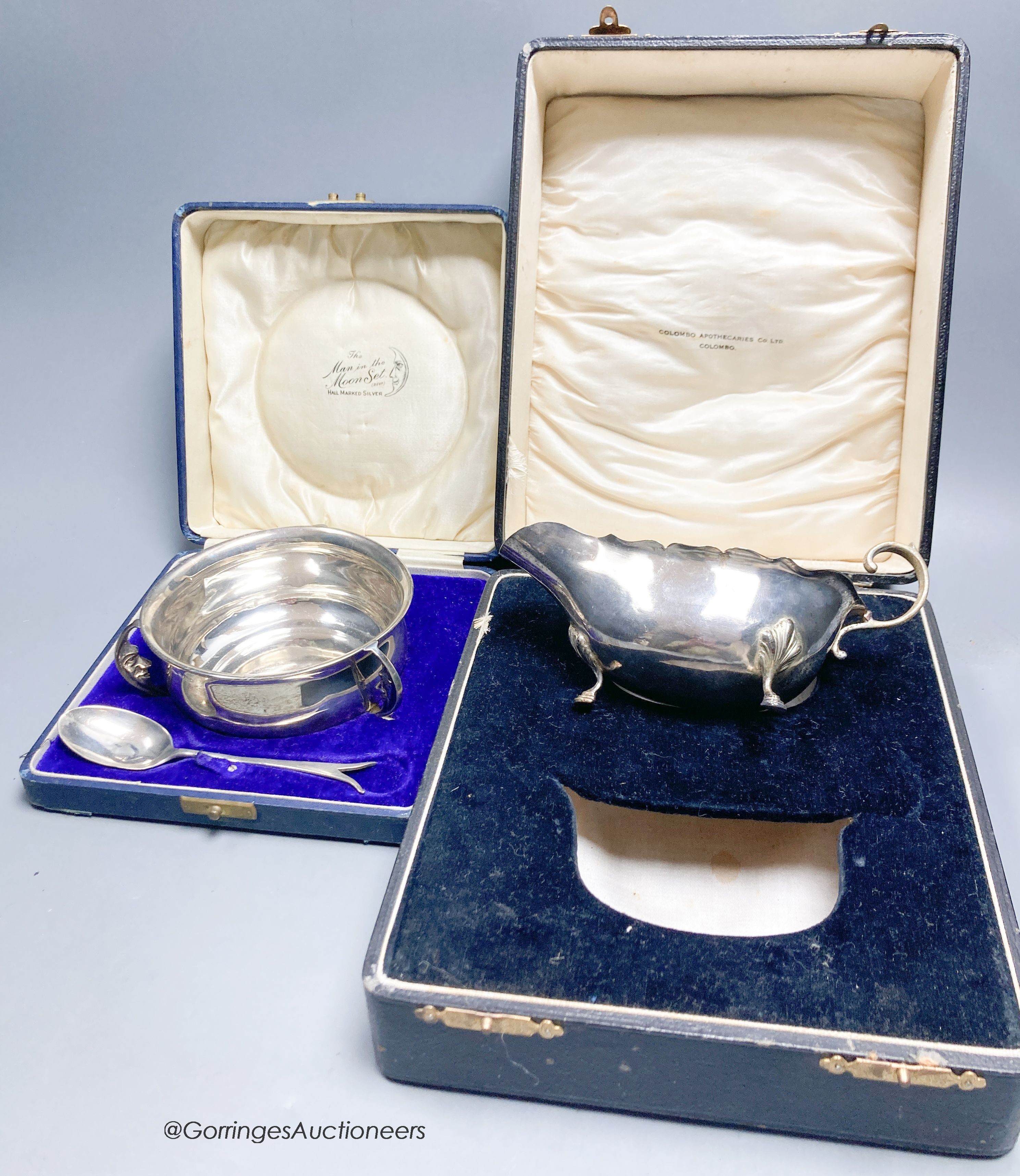 A cased 1920's silver porringer and spoon and cased sauceboat, 6.5oz.